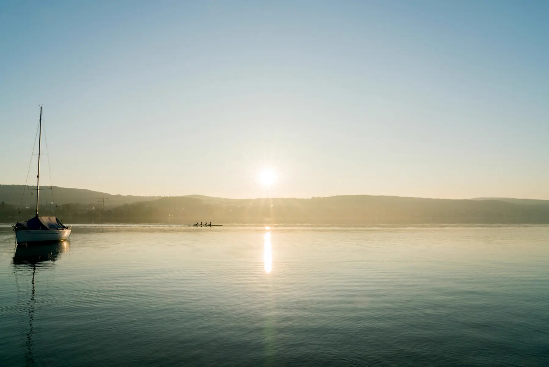 Segelboot auf dem Zürichsee im frühen Morgenlicht